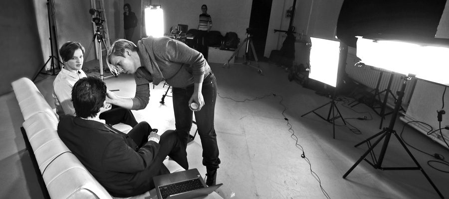 Eine Maskenbildnerin macht die letzten Handgriffe am Filmset vor den Filmaufnahme für ein Interview.